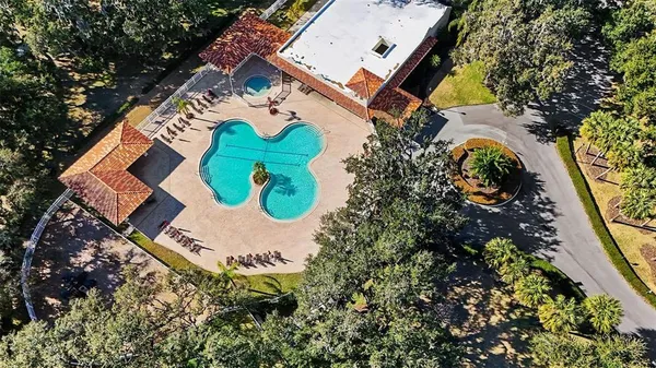 an aerial view of a house with a swimming pool and a yard