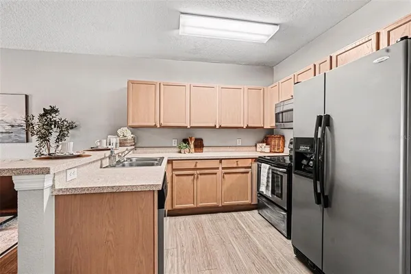 a kitchen with stainless steel appliances granite countertop a sink stove refrigerator and cabinets