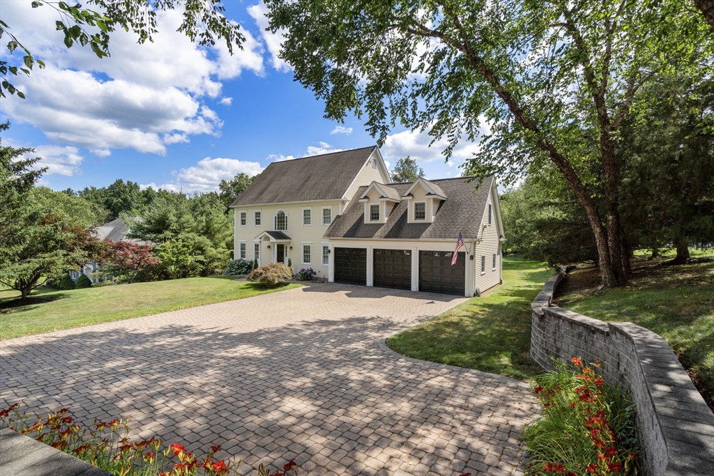 63 High Street Shrewsbury, MA 01545 - Photo 1 of 40 a front view of a house with a garden and trees