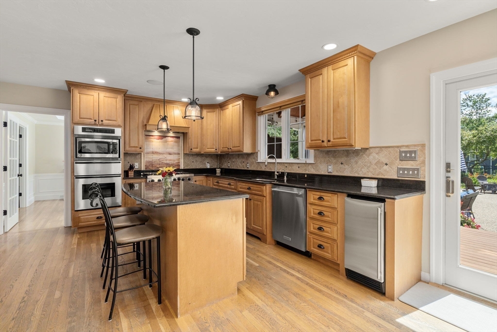 63 High Street Shrewsbury, MA 01545 - Photo 13 of 40 a kitchen with stainless steel appliances granite countertop a stove a sink dishwasher a microwave oven and a dining table with wooden floor