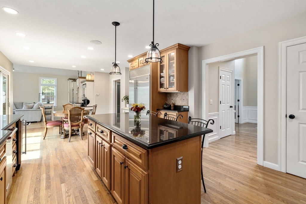 63 High Street Shrewsbury, MA 01545 - Photo 14 of 40 a kitchen with granite countertop a table chairs stove and a wooden floor