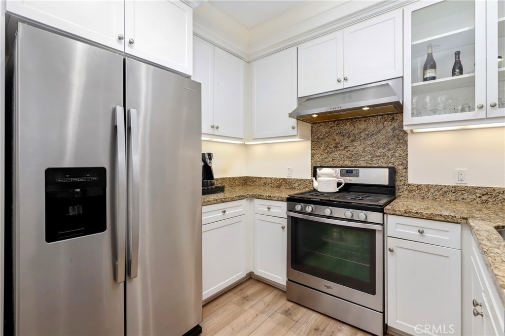 59 Kempton Irvine, CA 92620 - Photo 12 of 29 a kitchen with stainless steel appliances granite countertop a refrigerator stove and white cabinets