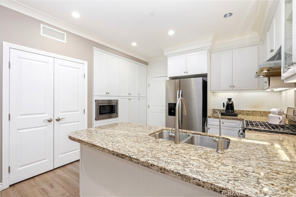 59 Kempton Irvine, CA 92620 - Photo 13 of 29 a kitchen with kitchen island a sink appliances and cabinets