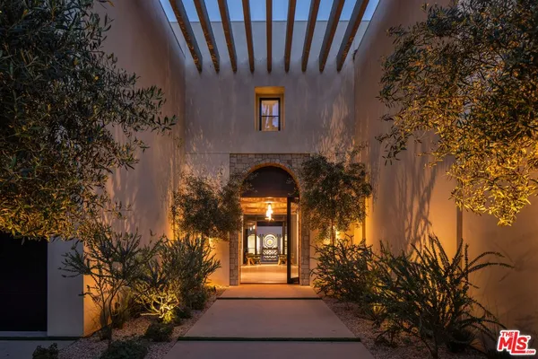 a front view of a house with large trees