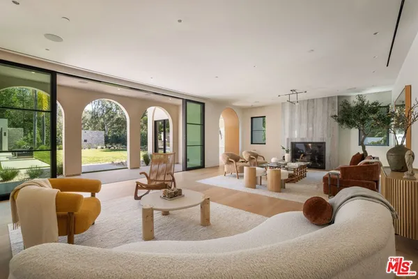 a living room with fireplace furniture and a large window