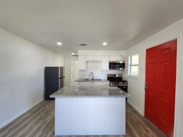 a kitchen with stainless steel appliances granite countertop a refrigerator stove microwave and sink