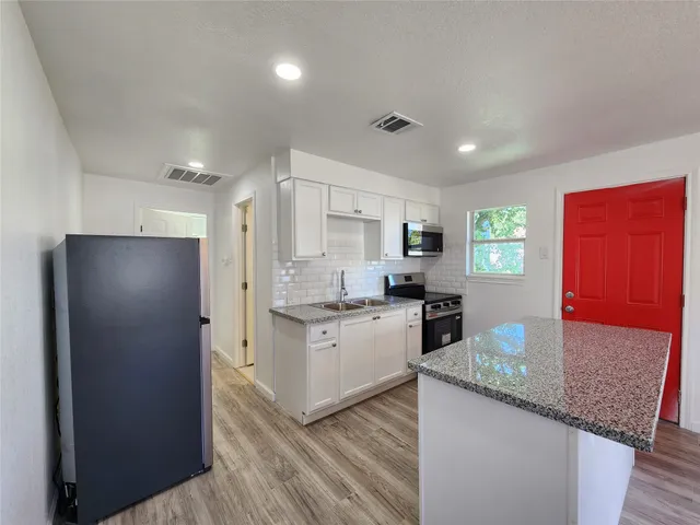 a kitchen with stainless steel appliances granite countertop refrigerator sink and microwave