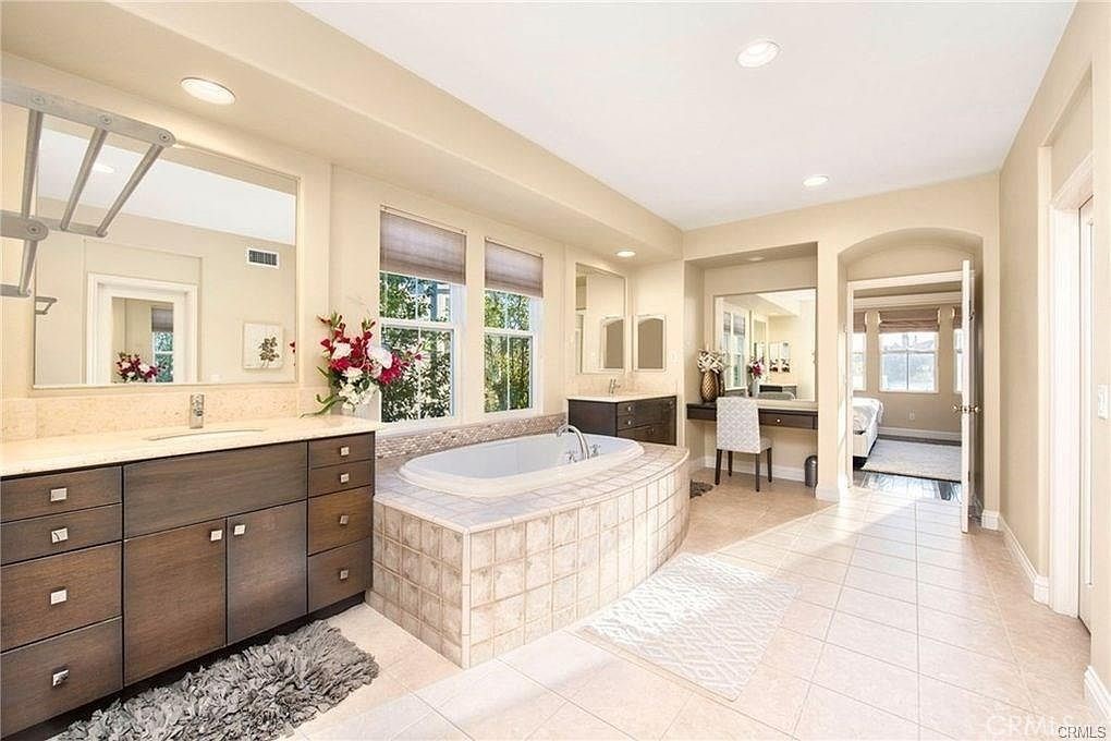 32 Walnut Creek Irvine, CA 92602 - Photo 18 of 24 a spacious bathroom with a tub sink and mirror