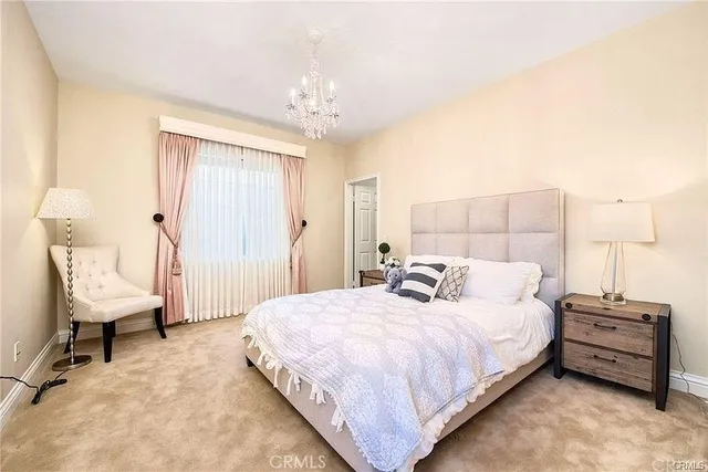 a bedroom with bed and a chandelier