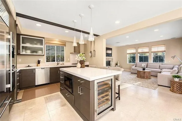 a kitchen with a stove a refrigerator a sink a dining table and chairs with wooden floor