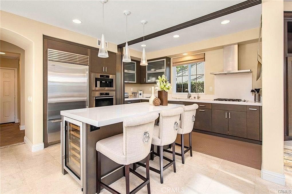 32 Walnut Creek Irvine, CA 92602 - Photo 6 of 24 a kitchen with a table chairs refrigerator and cabinets