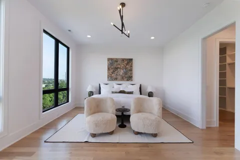 an empty room with wooden floor mirror and windows