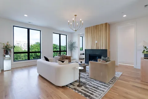 a living room with furniture a large window and a fireplace