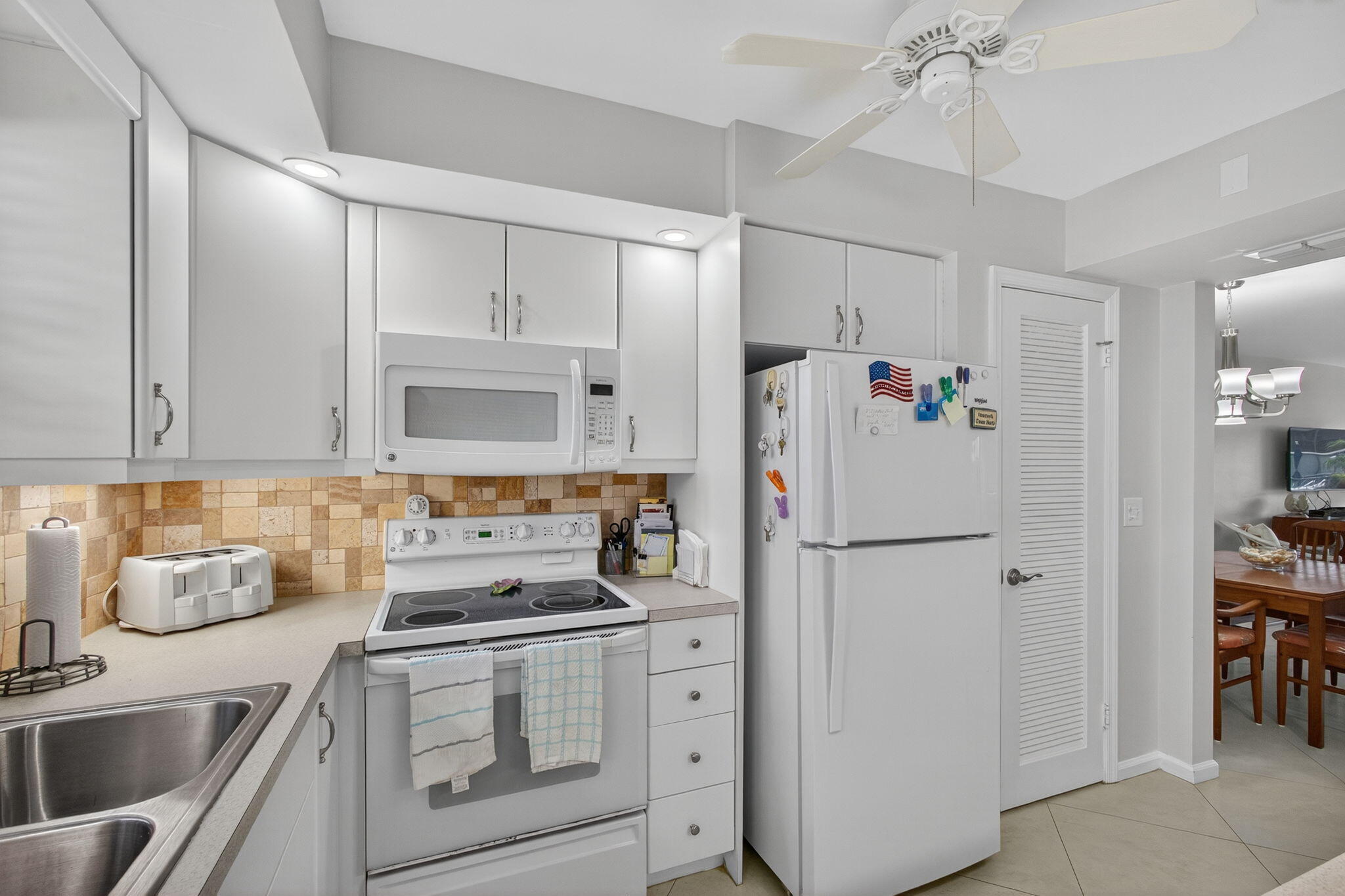 755 Saturn Street, Unit C105 Jupiter, FL 33477 - Photo 11 of 36 a white refrigerator freezer sitting inside of a kitchen