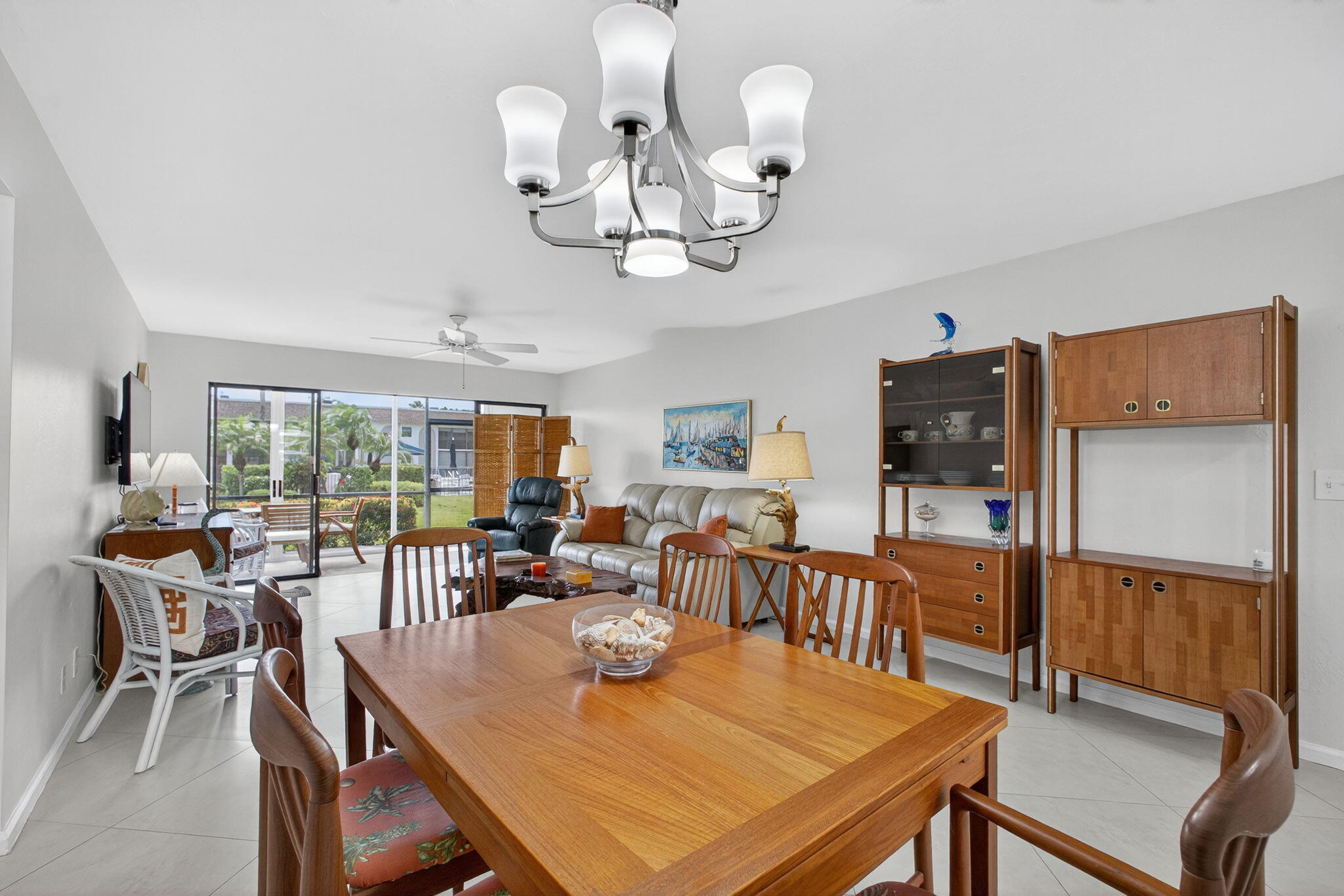 755 Saturn Street, Unit C105 Jupiter, FL 33477 - Photo 14 of 36 a view of a dining room with furniture a chandelier and large windows