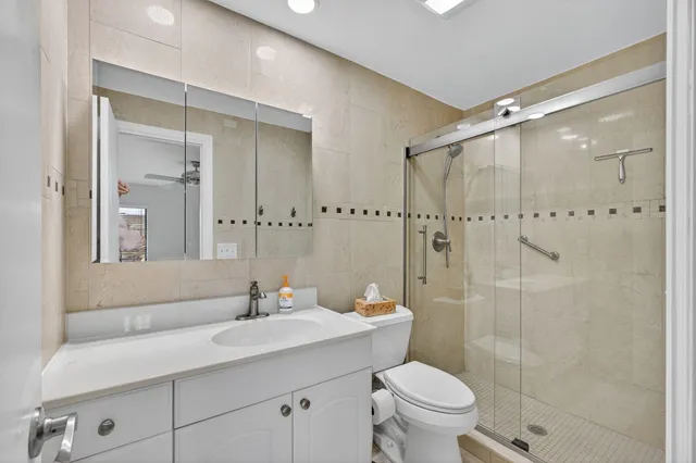 a bathroom with a sink toilet vanity and shower
