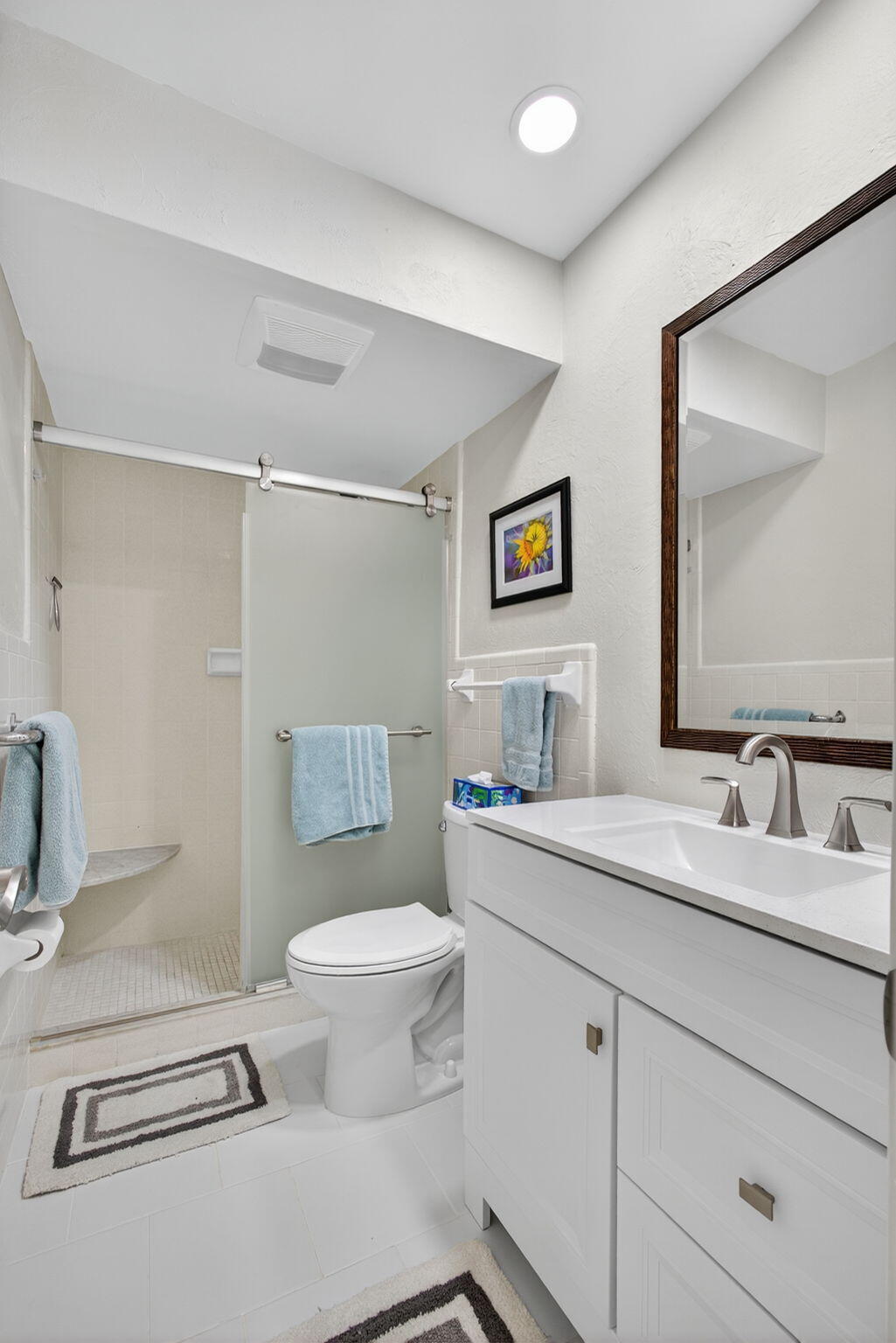 755 Saturn Street, Unit C105 Jupiter, FL 33477 - Photo 23 of 36 a bathroom with a toilet sink and mirror