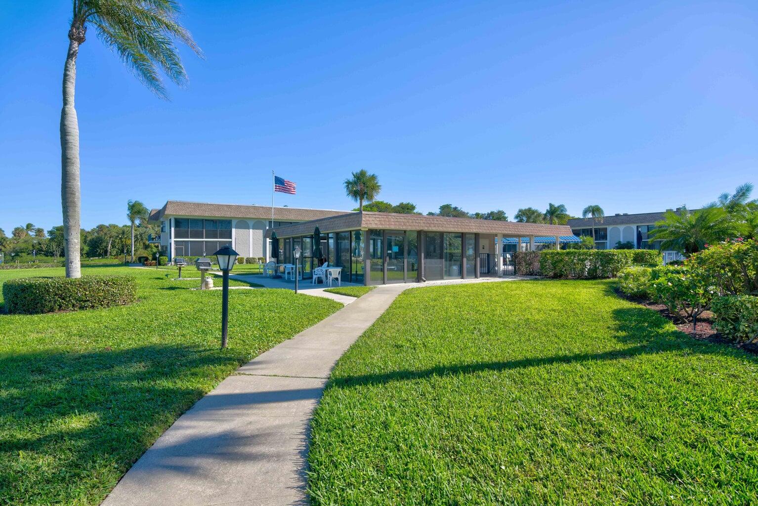755 Saturn Street, Unit C105 Jupiter, FL 33477 - Photo 34 of 36 a view of a house with a yard