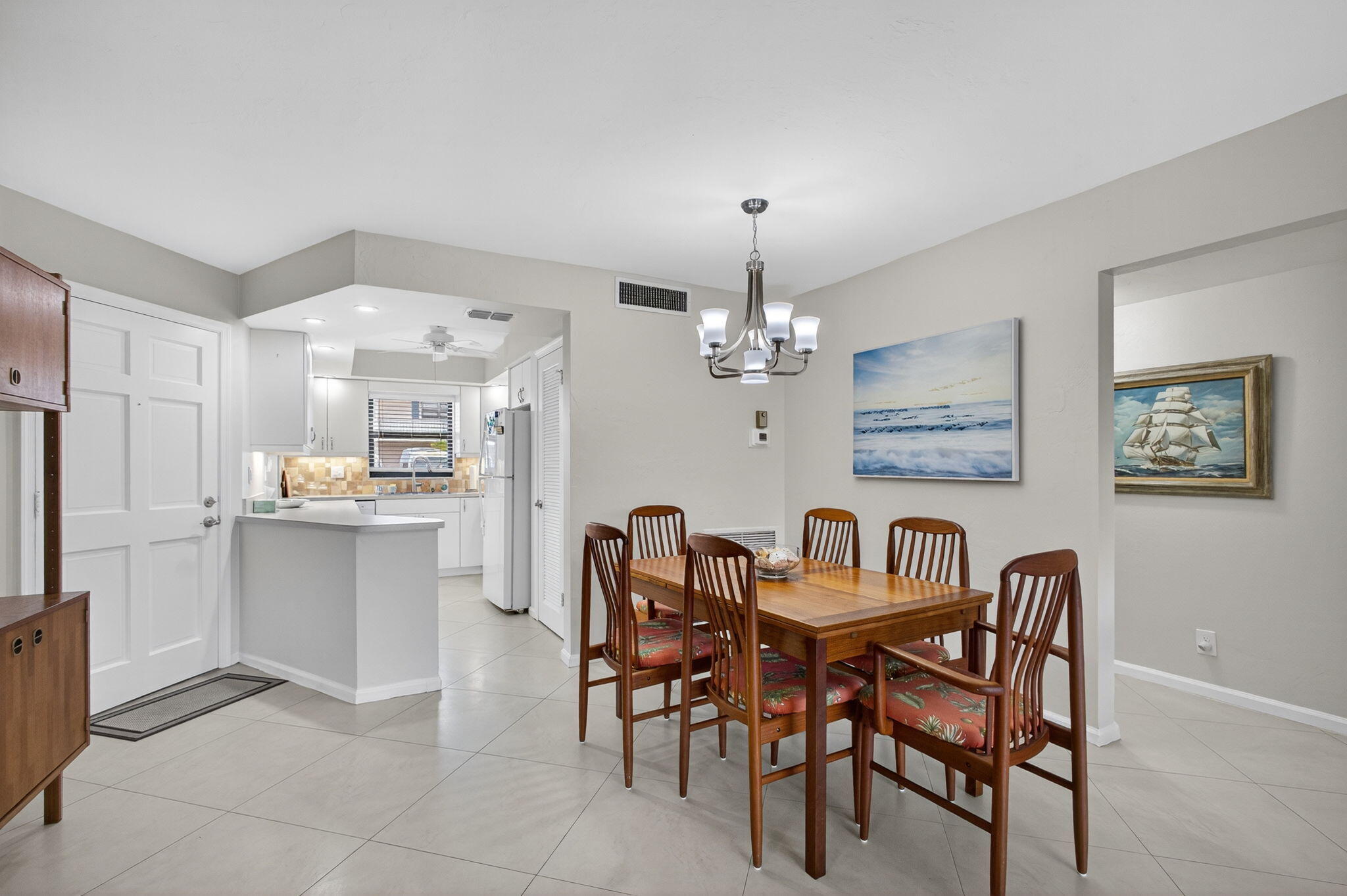 755 Saturn Street, Unit C105 Jupiter, FL 33477 - Photo 7 of 36 a view of a dining room with furniture and chandelier