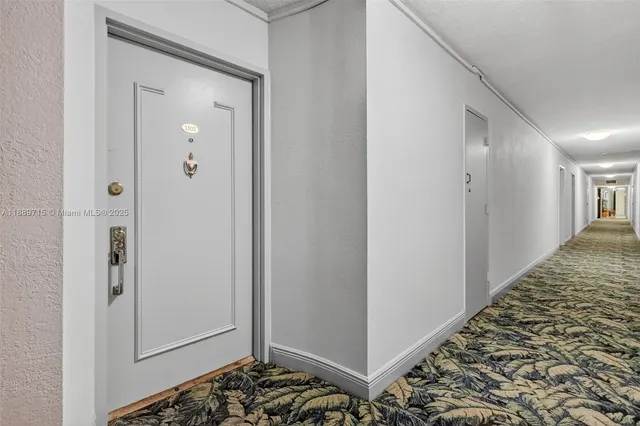 a view of a hallway with wooden floor and a bathroom