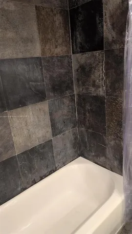 a spacious bedroom with a bed and wooden floor