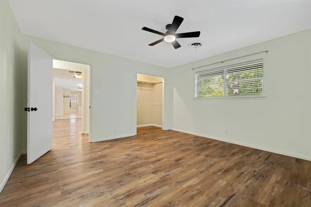 a view of a livingroom with wooden floor and a ceiling fan
