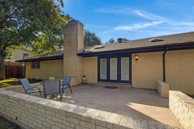 a view of a patio with table and chairs with wooden floor and fence