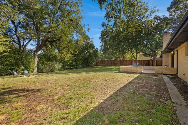 a view of a yard with large trees