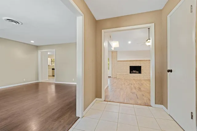 a view of a hallway with wooden floor and a living room
