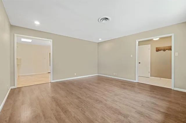 a view of an empty room with wooden floor and closet