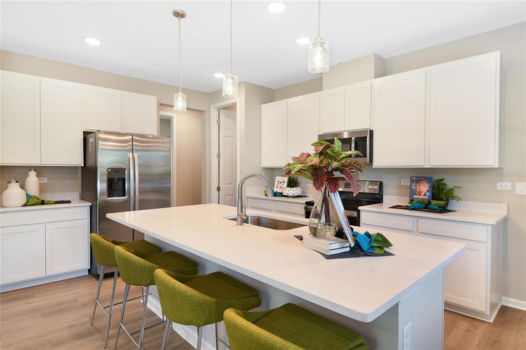 5331 Spring Maiden Circle Apollo Beach, FL 33572 - Photo 6 of 29 a kitchen with kitchen island a table and chairs in it