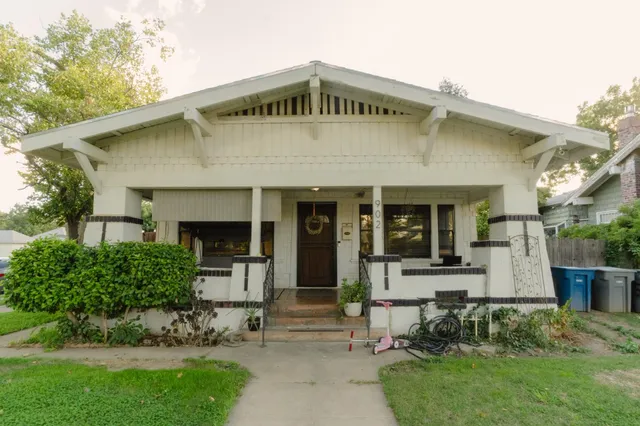 a front view of a house with a garden and plants