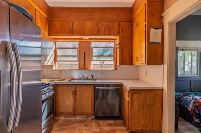 a kitchen with stainless steel appliances granite countertop a sink and a refrigerator