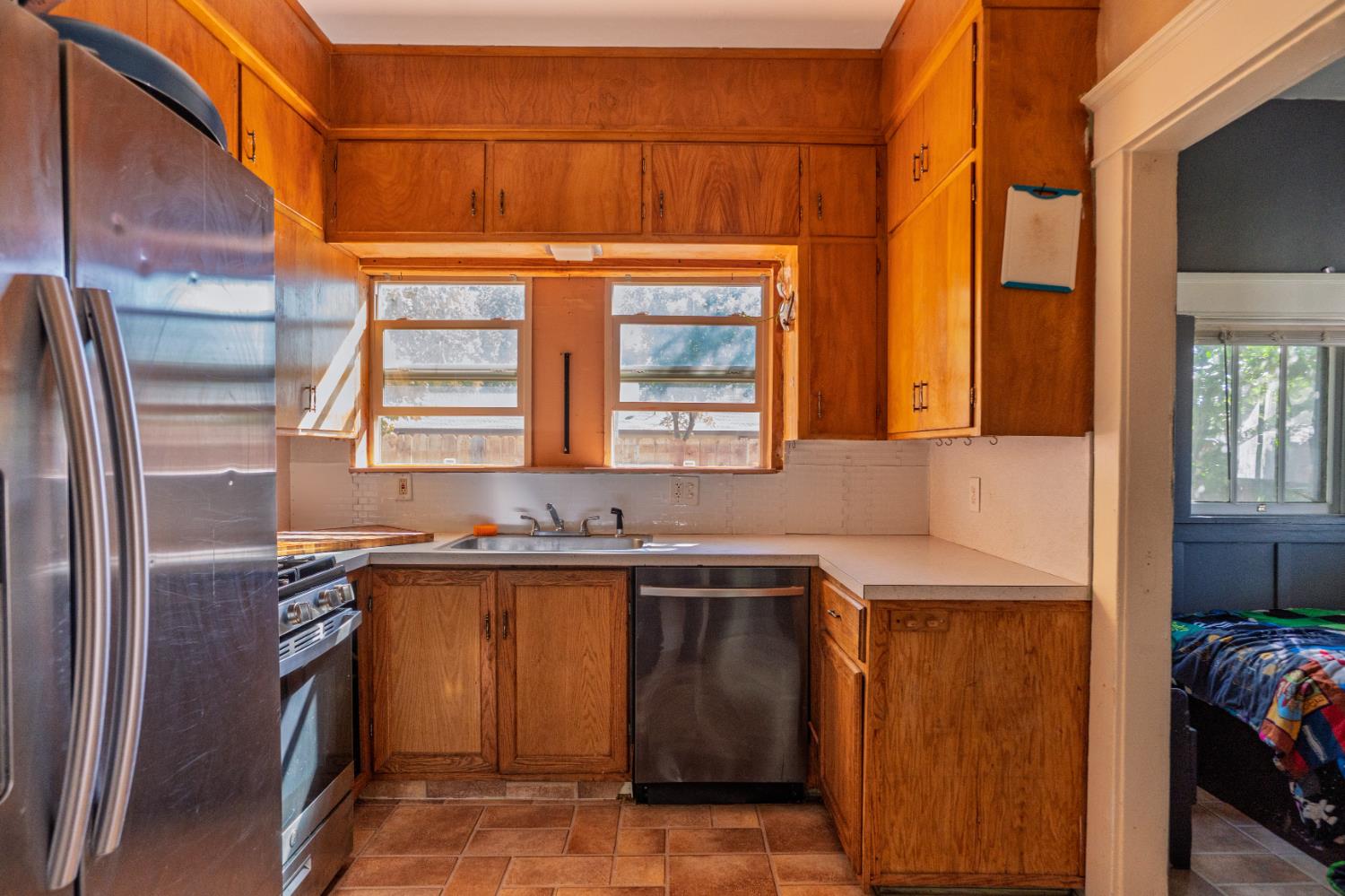 902 West 20th Street Merced, CA 95340 - Photo 11 of 48 a kitchen with stainless steel appliances granite countertop a sink and a refrigerator