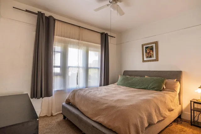 a bedroom with a large bed and a window