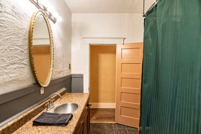 a bathroom with a granite countertop sink and a mirror