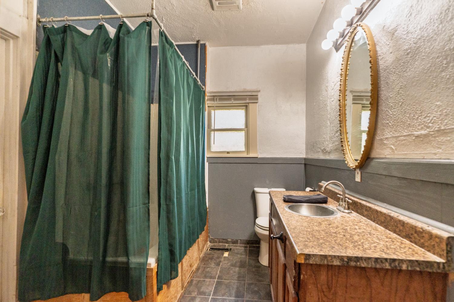 902 West 20th Street Merced, CA 95340 - Photo 25 of 48 a bathroom with a granite countertop sink and a mirror