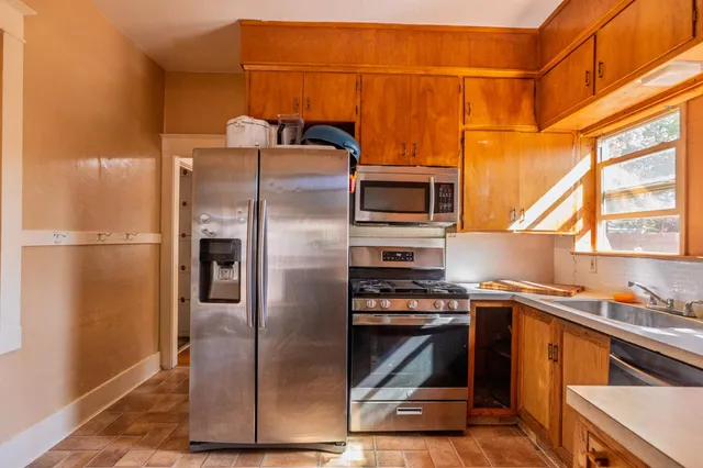 a kitchen with stainless steel appliances a refrigerator and a stove top oven