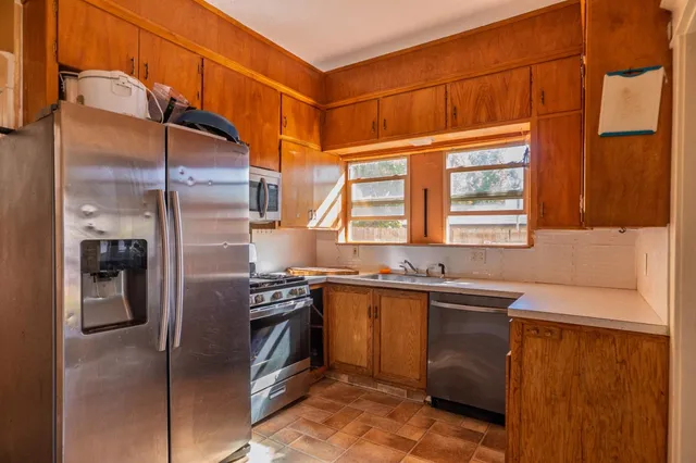 a kitchen with stainless steel appliances granite countertop a refrigerator and a sink
