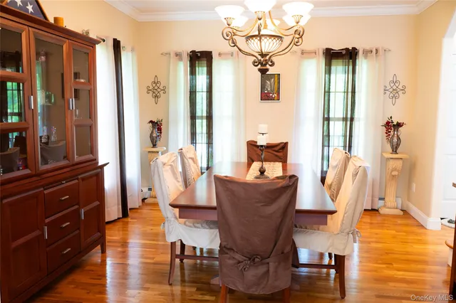 a dining room with furniture a chandelier and wooden floor