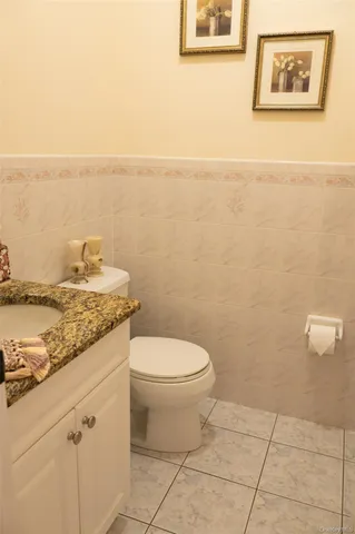a bathroom with a granite countertop toilet and a sink