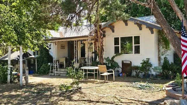 a view of a white house with large windows and a tree