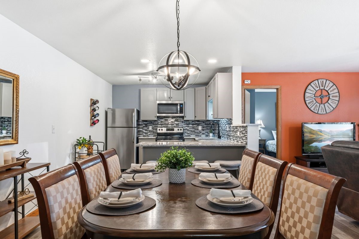 89410 Ryan Gulch Road, Unit 208 Silverthorne, CO 80498 - Photo 8 of 30 a view of a dining room with furniture a chandelier and wooden floor