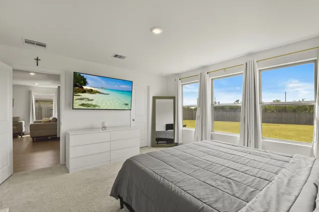 a bedroom with a bed and a large window