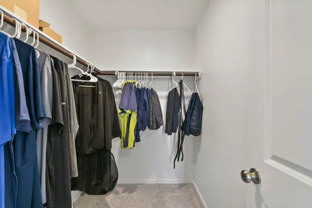 a view of walk in closet with clothes and shoes