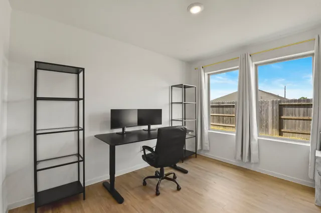 a view of a workspace with furniture and a window