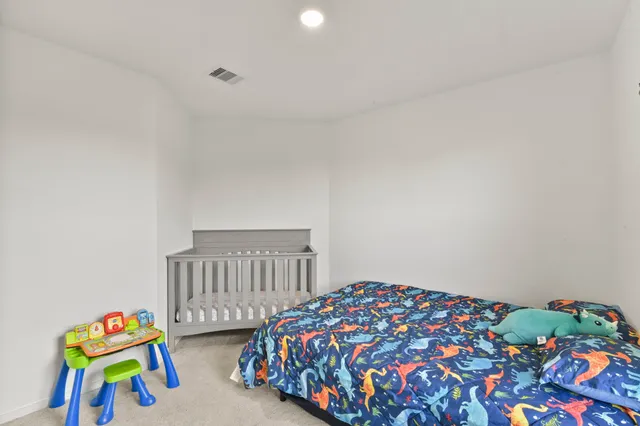 a bedroom with bed and a baby crib