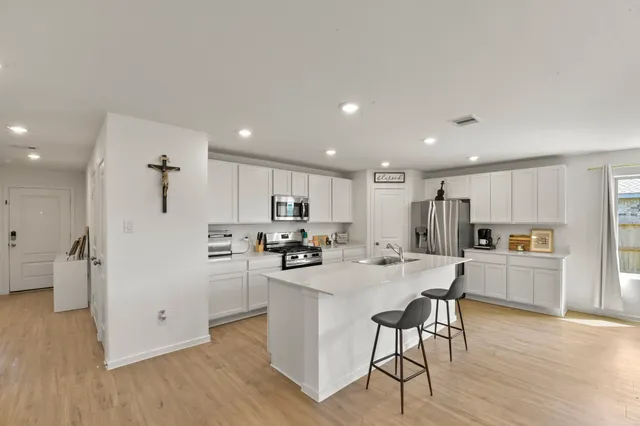 a kitchen with stainless steel appliances kitchen island granite countertop a refrigerator and a stove top oven