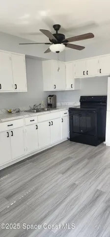 a kitchen with granite countertop a stove cabinets and a wooden floor