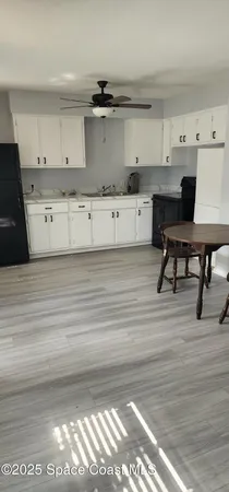 a kitchen with cabinets and wooden floor